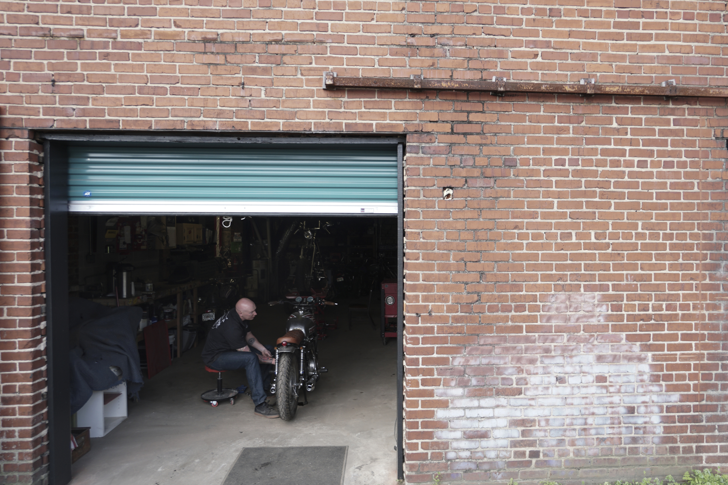 Staff Photo by Dan Henry / The Chattanooga Times Free Press- 3/28/16. Adam Sheard, owner of Speed Deluxe, works on restoring a '72 Honda CB 450 while at his shop's new North Chattanooga location off of Cherokee Boulevard on Monday, March 29, 2016.