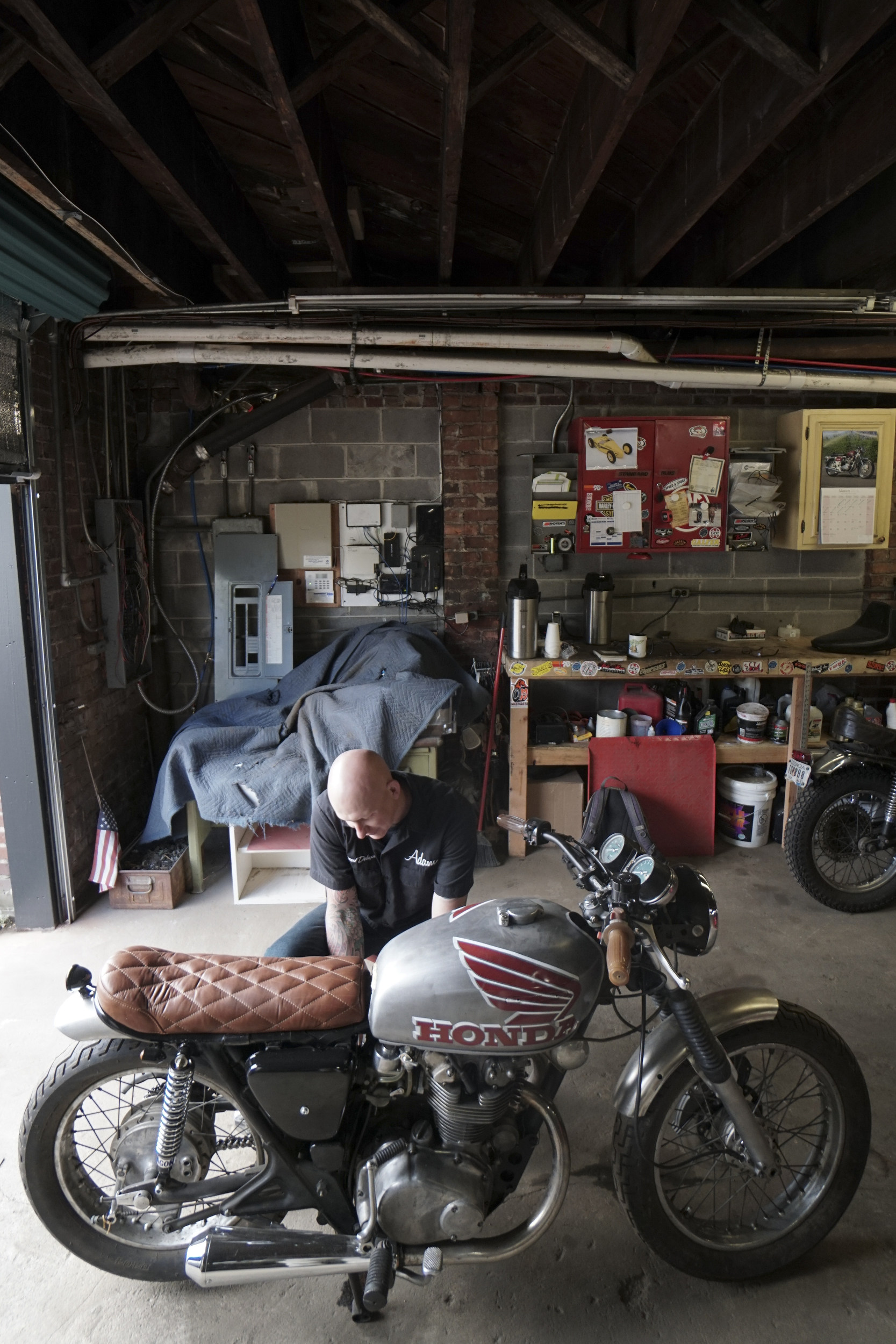 Staff Photo by Dan Henry / The Chattanooga Times Free Press- 3/28/16. Adam Sheard, owner of Speed Deluxe, works on restoring a '72 Honda CB 450 while at his shop's new North Chattanooga location off of Cherokee Boulevard on Monday, March 29, 2016.