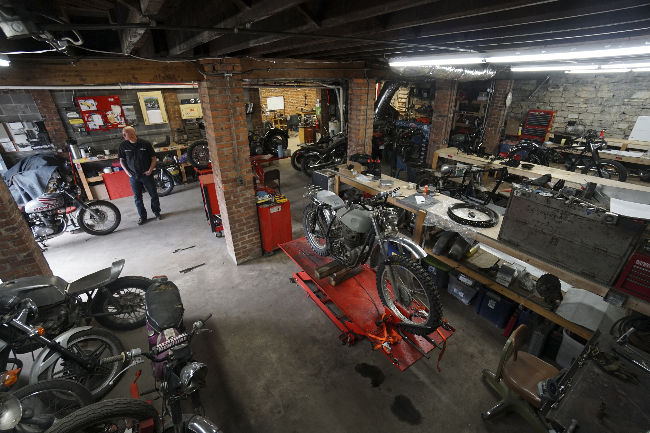 Staff Photo by Dan Henry / The Chattanooga Times Free Press- 3/28/16. Adam Sheard, owner of Speed Deluxe, works on restoring a '72 Honda CB 450 while at his shop's new North Chattanooga location off of Cherokee Boulevard on Monday, March 29, 2016.