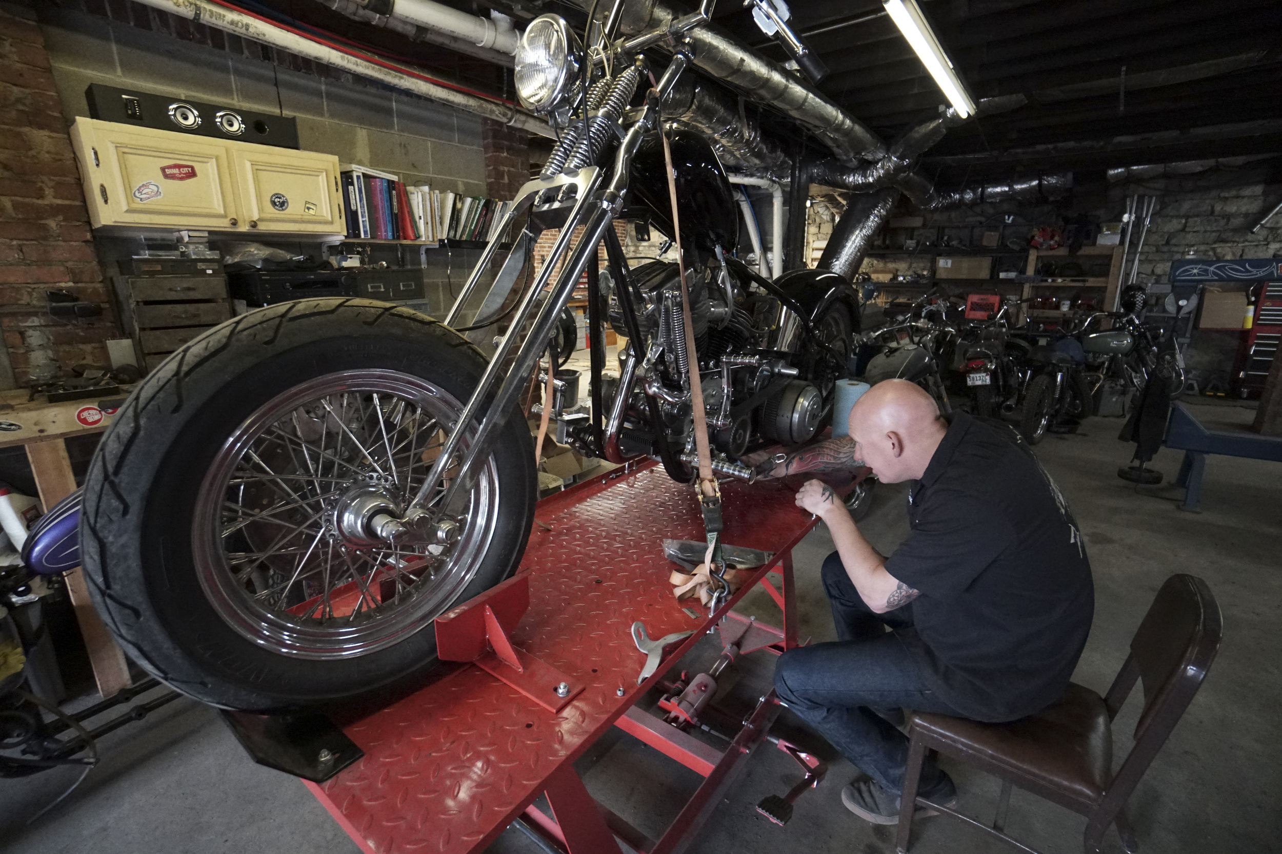 Staff Photo by Dan Henry / The Chattanooga Times Free Press- 3/28/16. Adam Sheard, owner of Speed Deluxe, works on restoring a '54 Pinhead Harley Davidson while at his shops new North Chattanooga location off of Cherokee Boulevard on Monday, March 29, 2016.