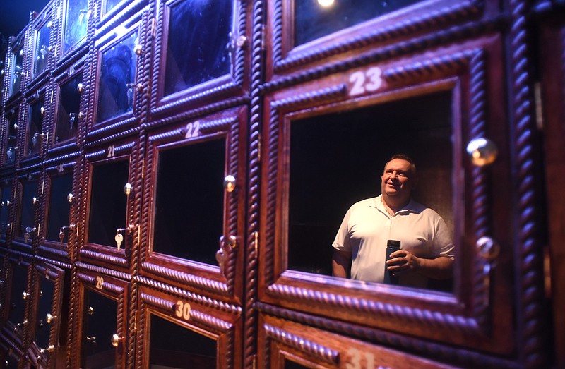 Owner Krist Biba is reflected in a wine box Friday, April 22, 2016 as he talks about his new restaurant, Full Moon American Burger and Bar.