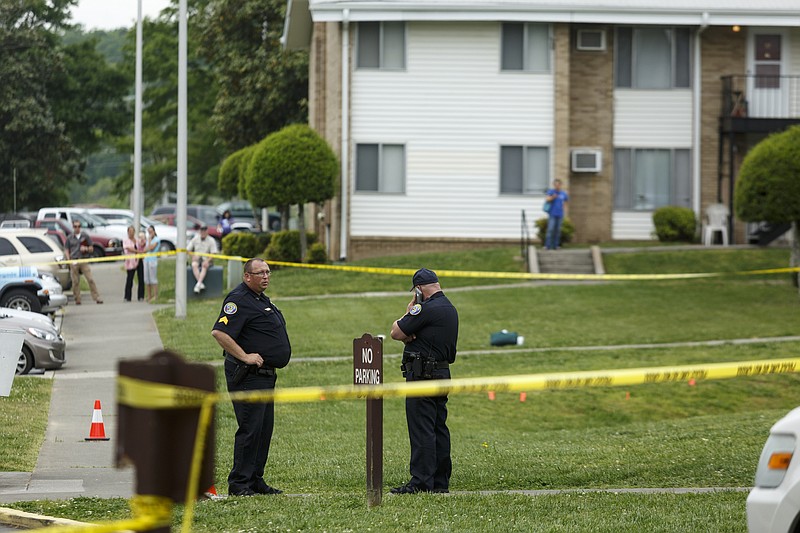 In this April 2016 file photo, Cleveland police stand at the perimeter of a scene after a triple-stabbing at Springbrook Apartments.