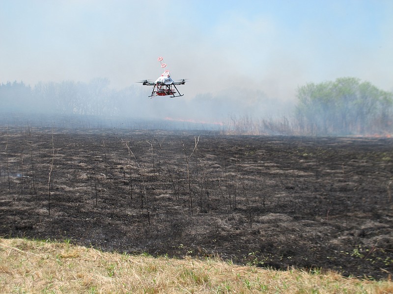 
              A drone designed to ignite controlled grass fires comes in for a landing in a field at the Homestead Monument of America in Beatrice, Neb., on Friday, April 22, 2016. University of Nebraska-Lincoln researchers are testing the drone as a possible tool for firefighters. (AP Photo/Grant Schulte)
            