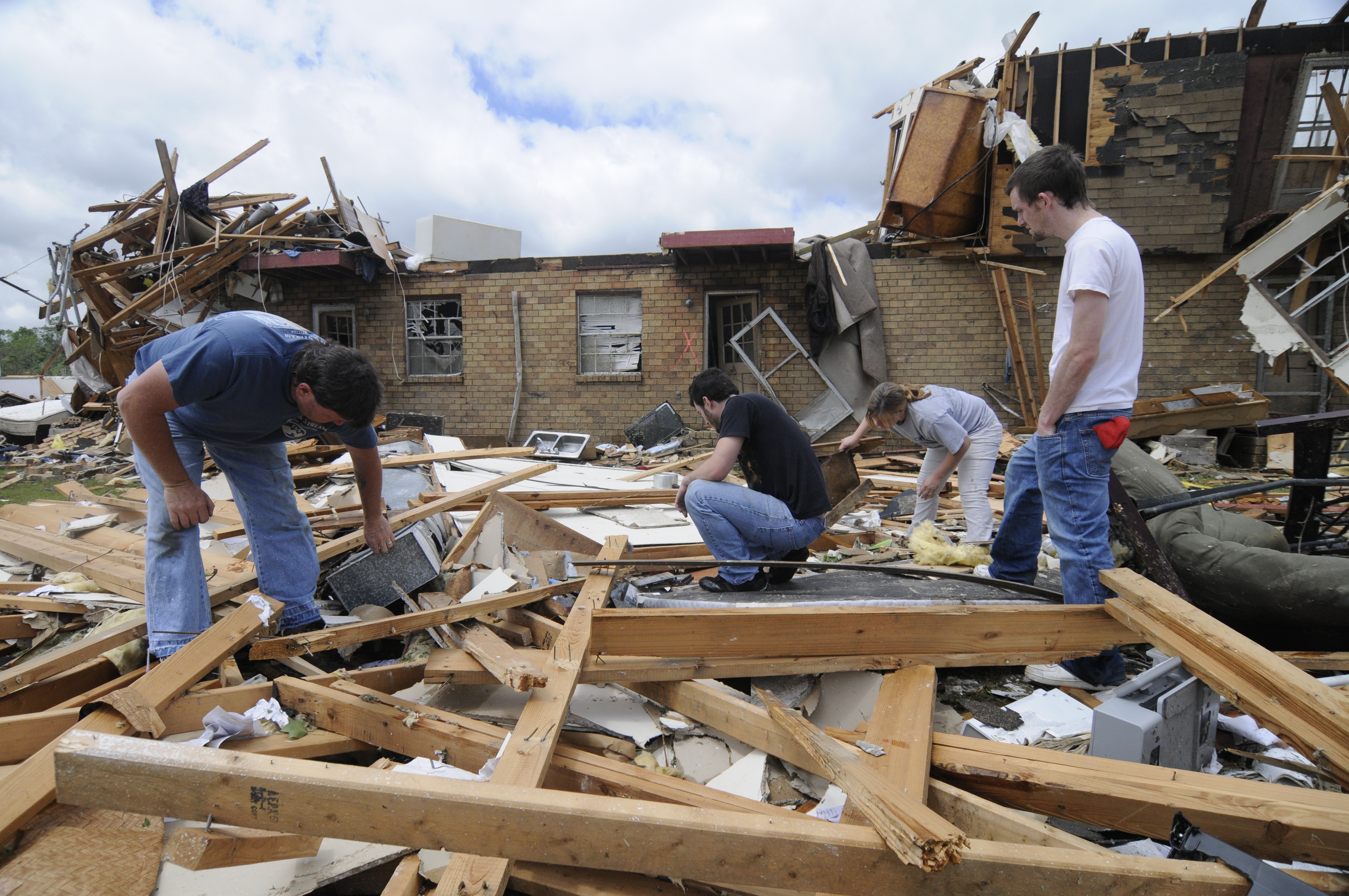 Charlie Hester, Walt Shrader, Janet Hester and Andy Page, from left, look through debris at the Village Green Apartments on April 28, 2001, in Trenton, Ga. Page lived in one of the upper units that were destroyed when three tornados touched down in Dade County.