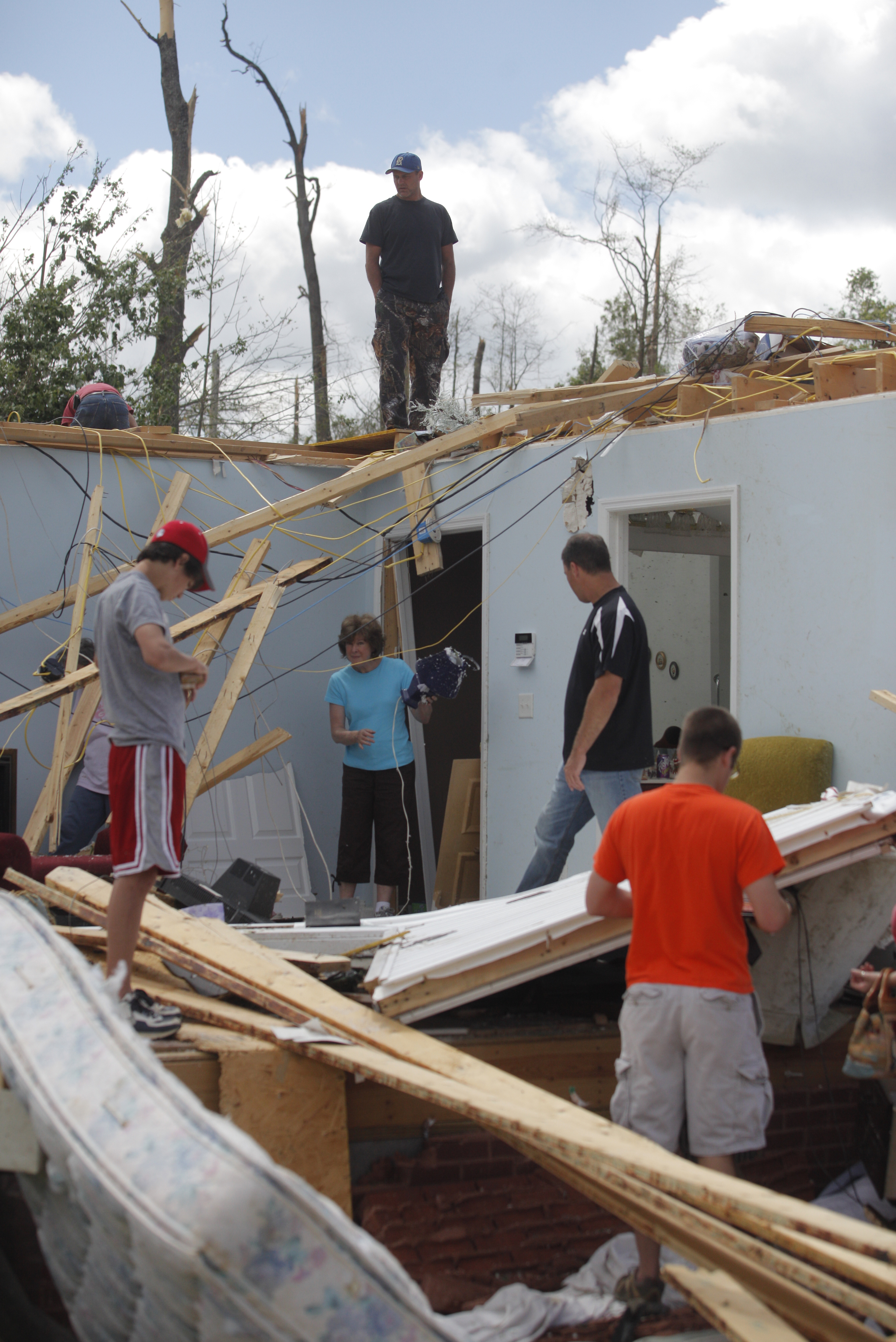 The Hemphill {CQ} family sifts through the wreckage of a home of a relative Thursday afternoon. The neighborhood along Cherokee Valley Rd. in Ringgold, Ga., was laid to waste by a tornado Wednesday night.