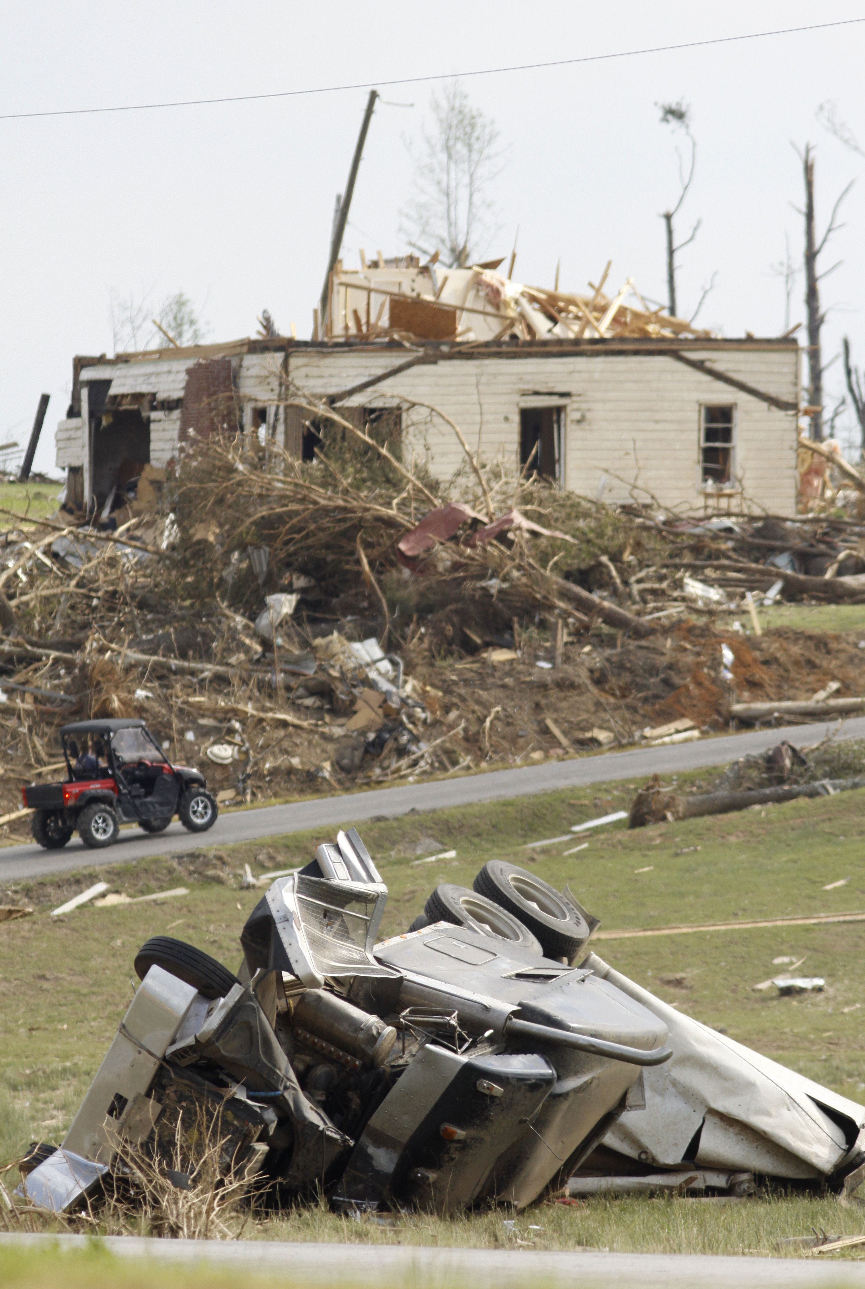 Staff Photo by Dan Henry - The Chattanooga Times Free Press. May 2, 2011. Emergency personnel drive past a crushed semi and demolished home while working in a Bridgeport, Al., neighborhood which was severely damaged after last weeks string of deadly tornadoes reeked havoc on the tri-state area.