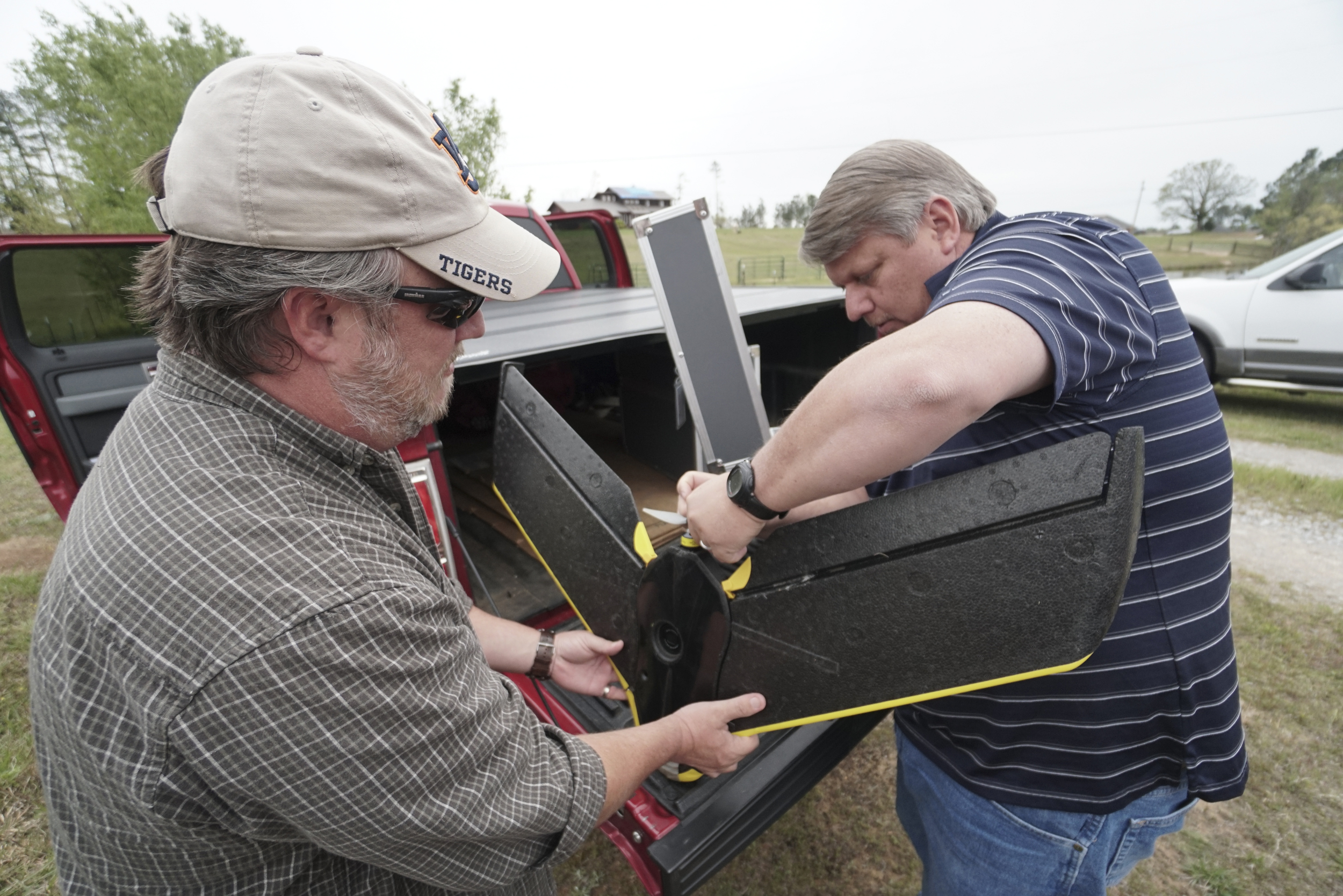 Staff Photo by Dan Henry / The Chattanooga Times Free Press- 4/13/16. Brandon Reed, left, and Mark Warner with "enrGies Operations", repair a fixed wing autonomous drone after crashing it at takeoff on Wednesday, April 13, 2016. They are using it to photograph damage patterns from a tornado that formed two weeks ago near Priceville, Alabama. The team is working in conjunction with the Southeast Vortex Campaign in performing research to support a hypothesis that surface friction and topography play a role in the formation of tornadoes.