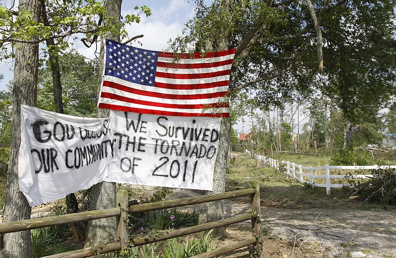 Staff Photo by Dan Henry - The Chattanooga Times Free Press. May 2, 2011. A flag and uplifting banner are posted off of Clonts Rd. where last week's tornado reeked havoc on the Apison, Tenn., community.