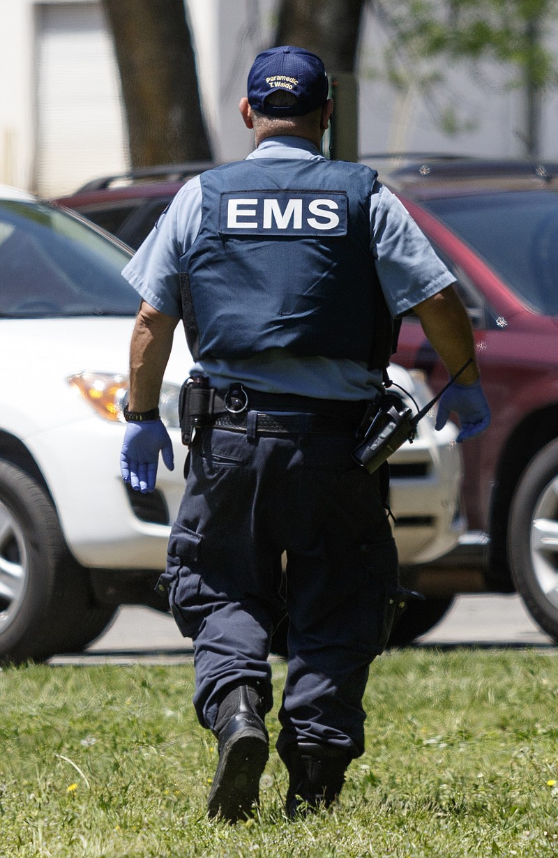 An EMS worker wears a bulletproof vest to respond to a call at Clifton Hills Elementary School on Wednesday, April 20, 2016, after a wave of gang violence in Chattanooga, Tenn.