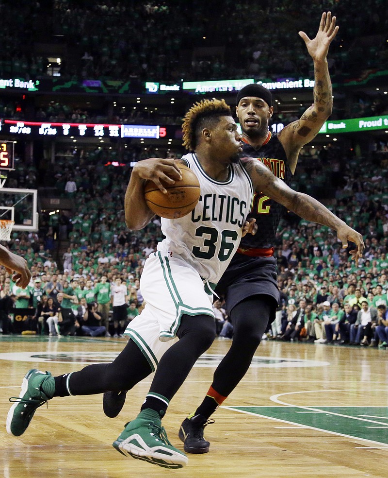 Boston Celtics guard Marcus Smart (36) drives against Atlanta Hawks forward Mike Scott during the third quarter in Game 3 of a first-round NBA basketball playoff series Friday, April 22, 2016, in Boston. (AP Photo/Elise Amendola)
