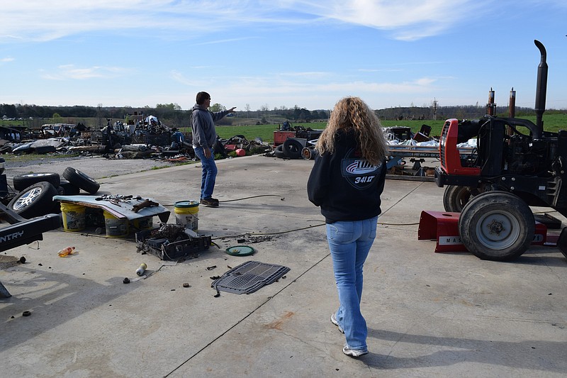 Kenny and Julia Kizzar, from left, stand amid rusting salvage parts from their business, Kizzar Automotive, in Bledsoe County's Pitts Gap community. The Kizzars are still trying to work out a settlement with their insurance company for the damage left by the 2011 storms.