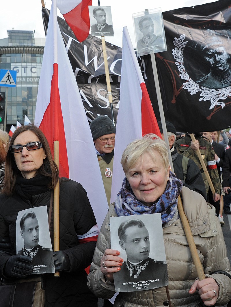 
              People carry portraits of Zygmunt Szendzielarz as they attend his funeral, in Warsaw, Poland, Sunday, April 24, 2016. Polish President Andrzej Duda and government ministers have taken part in the state burial of Szendzielarz, a World War II resistance commander and communist regime victim whose remains were found in a hidden mass grave. (AP Photo/Alik Keplicz)
            