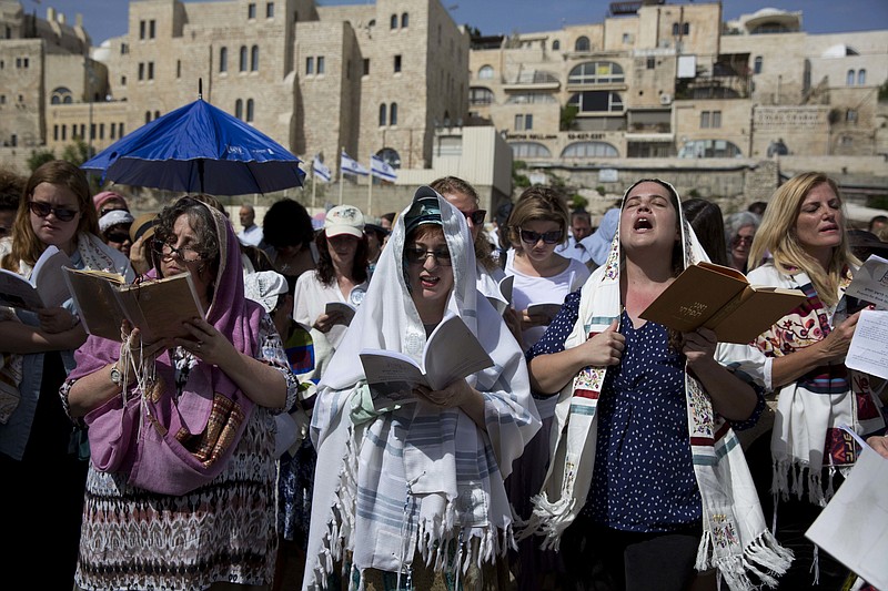 
              Jewish women wear prayer shawls as they pray during the Jewish holiday of Passover in front of the Western Wall, the holiest site where Jews can pray, in Jerusalem's Old City, Sunday, April 24, 2016. A liberal women's group has held a special Passover prayer service at a Jerusalem holy site, drawing criticism from the site's ultra-Orthodox rabbi, who called it a "provocation." (AP Photo/Ariel Schalit)
            