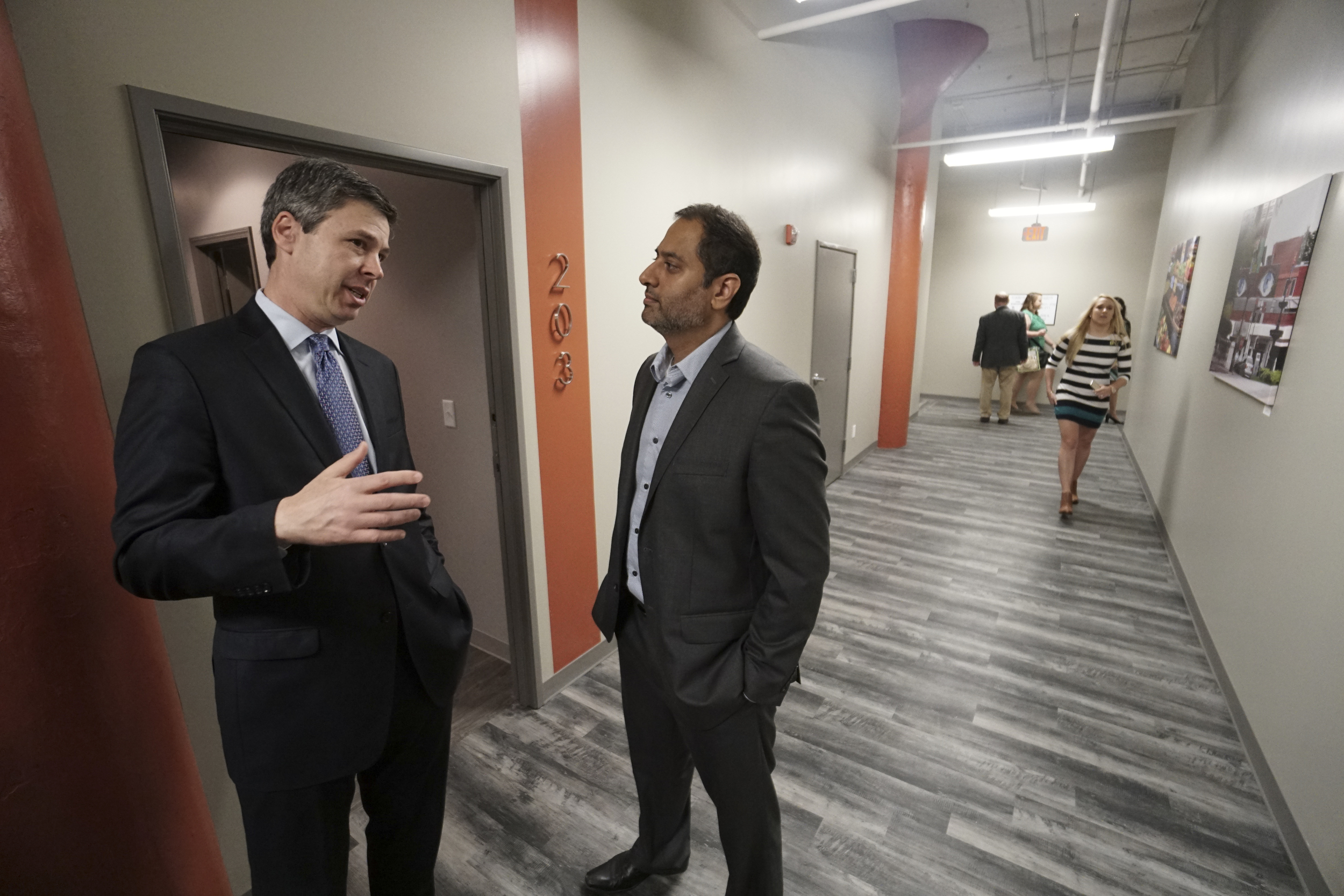 Chattanooga Mayor Andy Berke, left, talks with ViaNova Development Principal Vic Desai on March 31, 2016, on the grand-opening of The Clemons apartments downtown, which retrofitted the 100-year-old Clemons Bro. building at 730 Chestnut St. with 54 urban loft-style apartments.