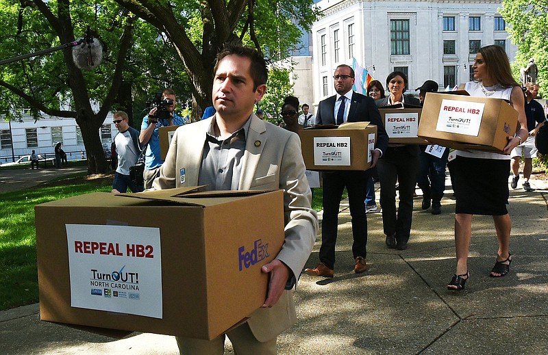 State Rep. Chris Sgro, D-Guilford, who is also executive director of Equality NC, leads a group carrying petitions calling for the repeal of House Bill 2 to Gov. Pat McCrory's office at the state Capitol building Monday, April 25, 2016, in Raleigh, N.C. Tempers are flaring as supporters and opponents of the new North Carolina transgender law hold competing rallies to sway legislators starting their annual session.