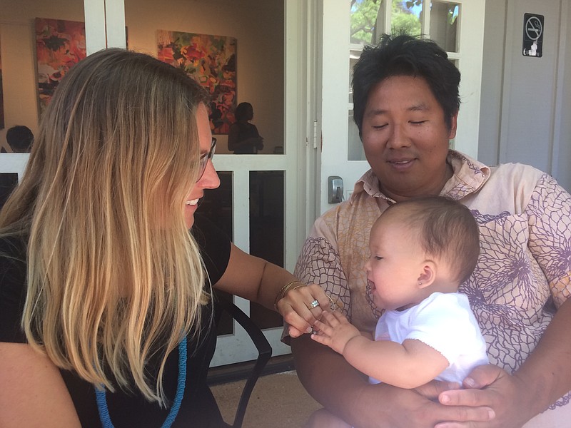 
              In this Thursday, April 14, 2016 photo, chef Mark Noguchi, right, and his wife Amanda Corby Noguchi play with their youngest daughter at Noguchi's restaurant Mission Social Hall and Cafe in Honolulu, Hawaii. The state agency promoting travel to Hawaii is starting an online video campaign to remind local residents about tourism’s benefits, including a video featuring Noguchi talking about tourism and his family. (AP Photo/Audrey McAvoy)
            