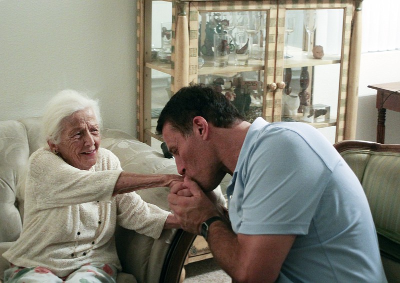 
              This April 22, 2016 photo Tony Robbins, a celebrity motivational speaker and philanthropist, kisses the hand of Evelyn Heller, 100, in her apartment in La Quinta, Calif. Heller was on the verge of homelessness after being evicted from another apartment on April 1, but found a new place to live thanks to social workers and a donation from Robbins. Robbins and a local congressman joined in helping her. (Gabby Ferreira/Palm Springs Desert Sun via AP) RIVERSIDE PRESS-ENTERPRISE OUT; NO SALES; NO FOREIGN; MANDATORY CREDIT
            