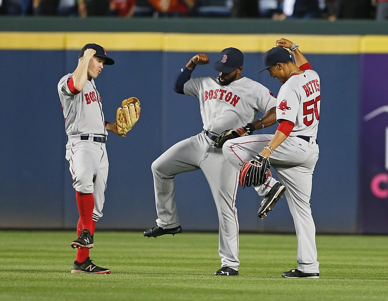 Boston Red Sox outfielders, from left, left fielder Brock Holt (12), center fielder Jackie Bradley Jr. (25) and right fielder Mookie Betts (50) celebrate after defeating the Atlanta Braves, 1-0, in a baseball game Monday, April 25, 2016, in Atlanta. Bradley scored the game's only run with a solo-home run in the seventh inning.