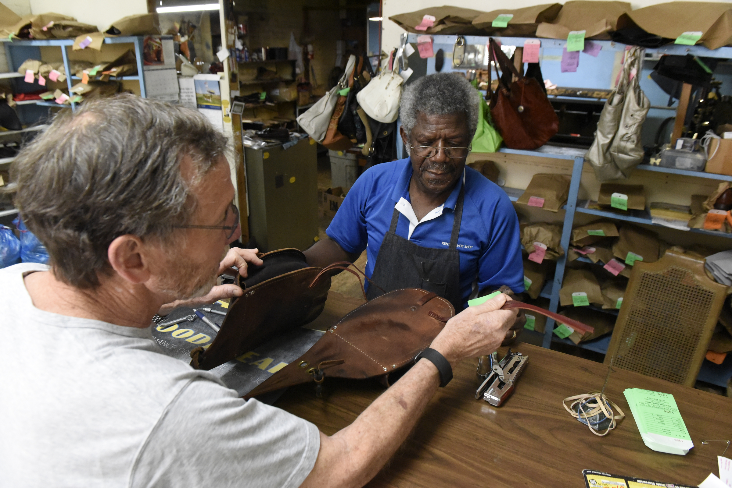 Reginald Cousin waits on customer Harry Austin at Kenton Shoe Shop, located at the corner of Broad and Eighth Streets Wednesday, Apr. 27, 2016, in Chattanooga, Tenn. A new building owner is remodeling, and Cousin, age 73, is closing his shop, the last shoe repair business in the downtown area.