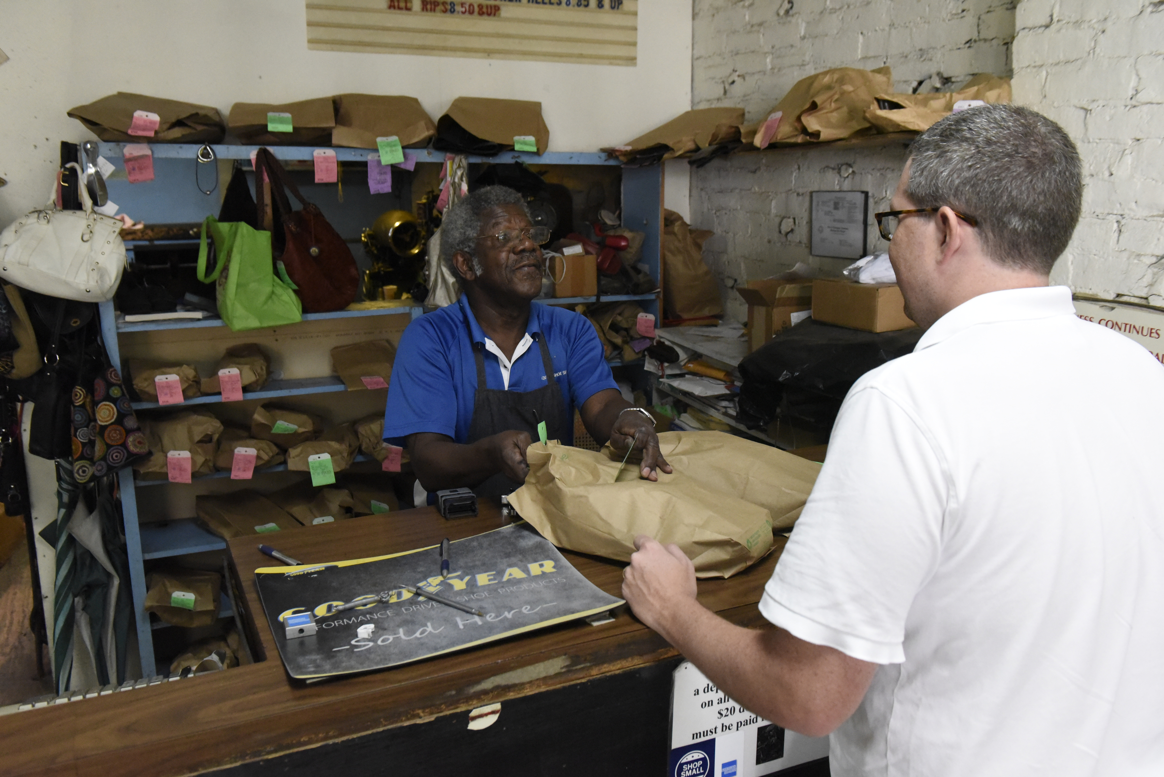 Reginald Cousin waits on customer Jeremy Cothern (CQ) at Kenton Shoe Shop, located at the corner of Broad and Eighth Streets Wednesday, Apr. 27, 2016, in Chattanooga, Tenn. A new building owner is remodeling, and Cousin, age 73, is closing his shop, the last shoe repair business in the downtown area.
