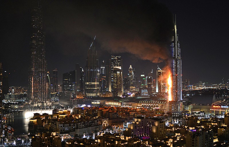 
              FILE- In this Thursday, Dec. 31, 2015 file photo, smoke and flames pouring from the Address Downtown Hotel in Dubai, United Arab Emirates. Officials in the United Arab Emirates are pondering how to change the country's fire safety laws after a series of skyscraper fires, including a dramatic New Year's Eve blaze seen around the world. (Sina Bahrami/@dearsina via AP, File) MANDATORY CREDIT
            