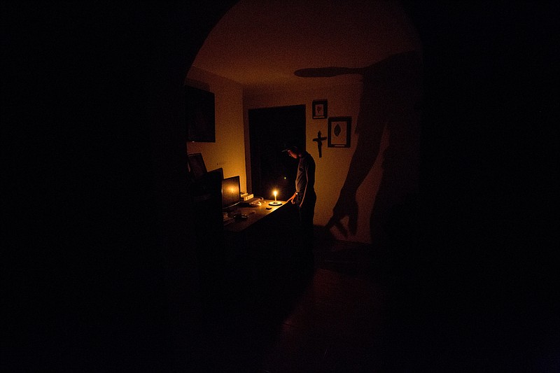 
              In this Saturday, April 23, 2016 photo, a boy illuminates his home with a candle during a 24-hour blackout, in the El Calvario neighborhood of El Hatillo, just outside of Caracas, Venezuela. Energy rationing has been added to the hardships faced by Venezuelans overwhelmed by inflation, shortages of food and medicine and rising crime. (AP Photo/Fernando Llano)
            