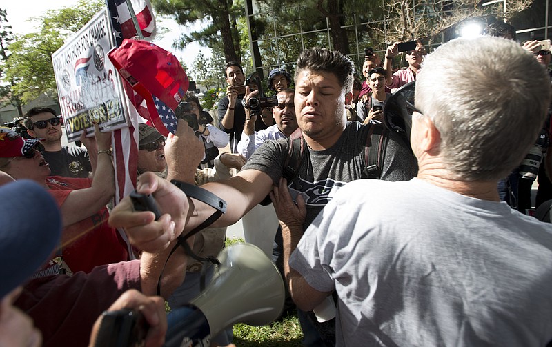 
              A man, center, sprays Republican presidential candidate Donald Trump supporters with pepper spray during a rally in front of the Anaheim City Hall on Tuesday, April 26, 2016, in Anaheim, Calif. (Leonard Ortiz/The Orange County Register via AP)   MAGS OUT; LOS ANGELES TIMES OUT; MANDATORY CREDIT
            