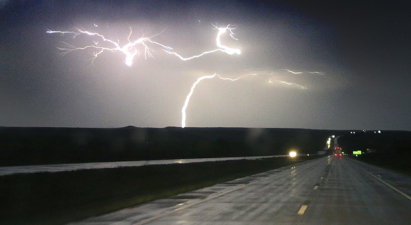 
              Lightning strikes along Interstate 70 near Junction City, Kan., Tuesday, April 26, 2016. Thunderstorms bearing hail as big as grapefruit and winds approaching hurricane strength lashed portions of the Great Plains on Tuesday. (AP Photo/Orlin Wagner)
            
