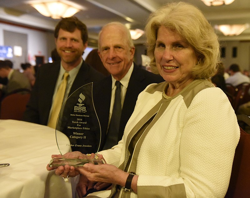 From left, Clarke Glover, Howard Glover and Becky Glover of Fisher Evans Jewelers are photographed with one of the Better Business Bureau's Torch Awards during the organization's annual luncheon at the Chattanoogan Hotel on Thursday, Apr. 28, 2016, in Chattanooga, Tenn. 