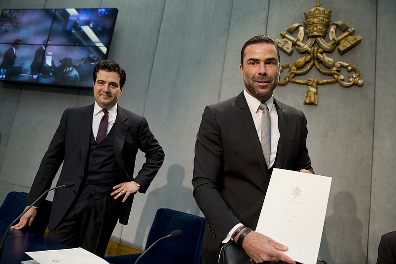 
              Rene Brulhart, president of the Vatican Financial Information Authority, right, flanked by Tommaso Di Ruzza, director of the Vatican Financial Information Authority, shows photographers a copy of the Vatican financial oversight report, as he arrives for a briefing at the Vatican press room, Thursday, April 28, 2016. The Vatican's financial watchdog said Thursday it received 544 reports of suspicious financial transactions last year, thanks in part to beefed-up efforts to flag potential tax cheats who are using the Vatican bank to hide money. (AP Photo/Andrew Medichini)
            
