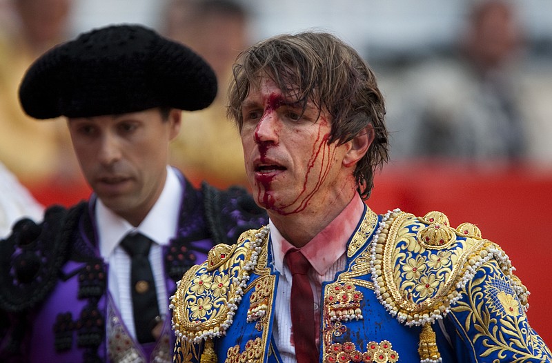 
              FILE - In this April 25, 2010 file photo, bullfighter Manuel Diaz "El Cordobes", right, reacts after being gored by a bull during a bullfight at the Monumental Bullring in Barcelona, Spain. The southern Cordoba city court has held a hearing into a decades-old paternity dispute over whether two of Spain's most well-known bullfighters and who share the same showname, 'El Cordobes', are really father and son. The court began studying the claim Thursday April 28, 2016 by Manuel Diaz, 47 that he is the son of retired bullfighting legend Manuel Benitez, 79, something the elder torero has never recognized. (AP Photo/Emilio Morenatti, File)
            