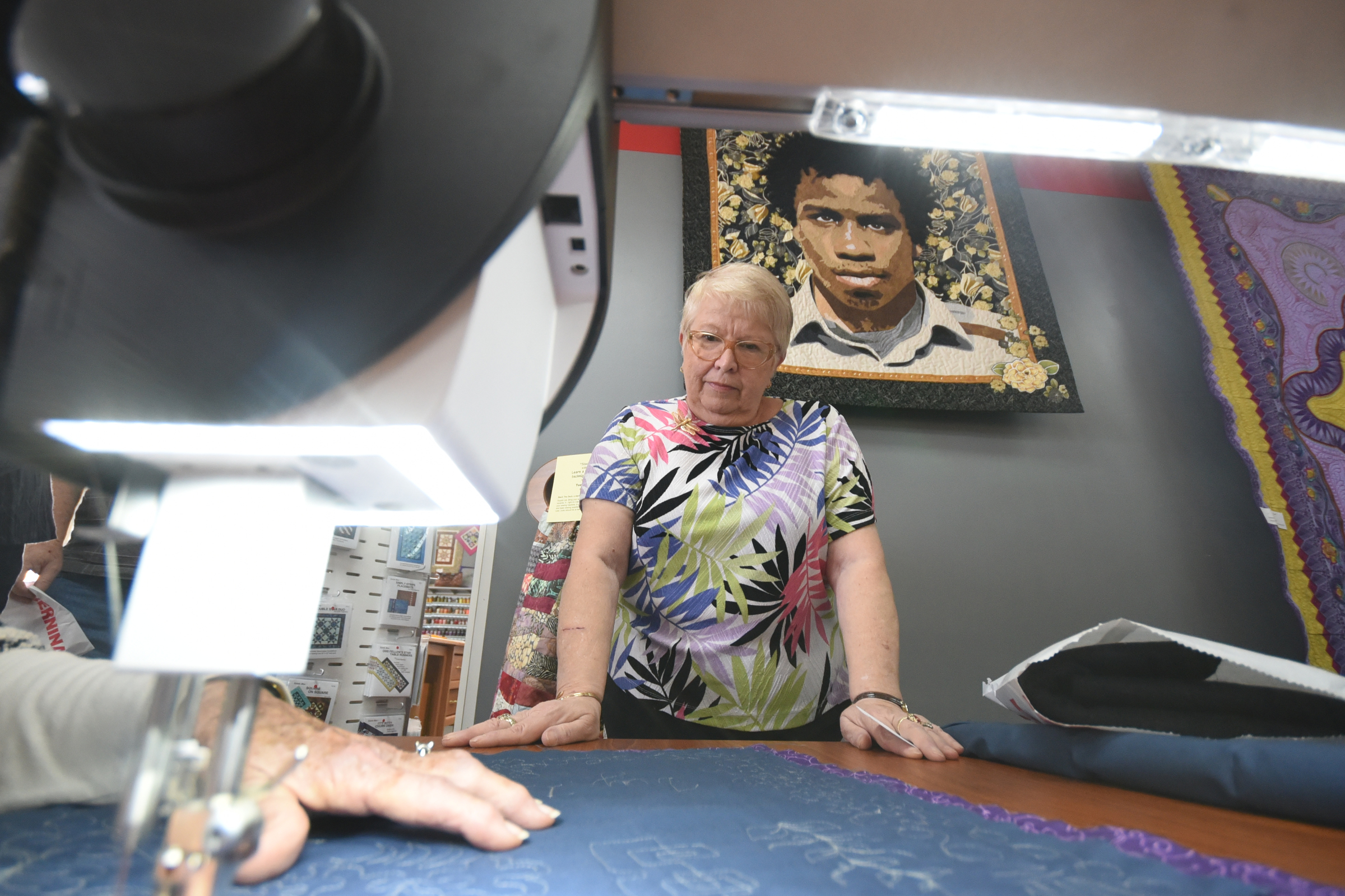 Former schoolteacher Kay Donges, of Suches, Ga., watches the hands of Gerry Haywood, who's using a free-motion sewing machine.