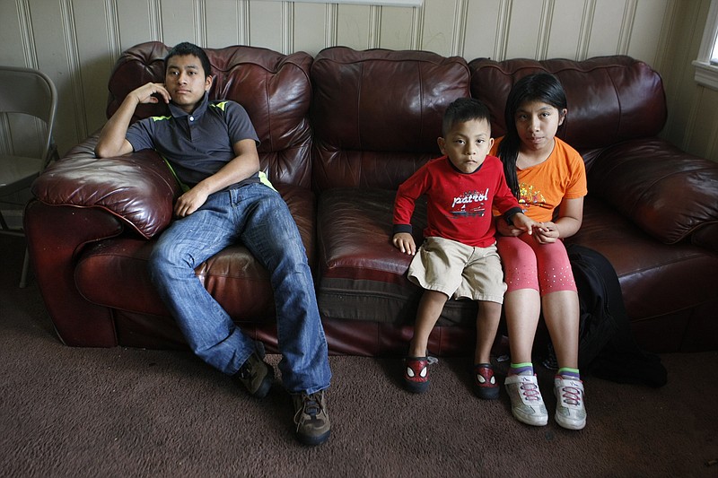 
              ADVANCE FOR MONDAY, MAY 2, 2016 AND THEREAFTER - In this April 21, 2016 photo, Melisa Jimon Reynoso, right, and her brother, Brian Jimon Reynoso, 3, center, sit with Candelario Jimon Alonzo, 16, left, at their home in Memphis, Tenn. Jimon joined his relatives when he arrived in Memphis after fleeing Guatemala. Local school officials have kept him out of the classroom since he tried to enroll in January. Attorneys say Jimon and at least a dozen other Central American unaccompanied youths have been blocked from going to high school in Memphis because officials said the teens lacked transcripts or were too old to graduate on time. (AP Photo/Karen Pulfer Focht)
            