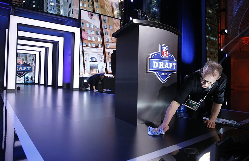 
              Robert Patterson prepare the stage at Auditorium Theater of Roosevelt University for the second and third rounds of the 2016 NFL football draft, Friday, April 29, 2016, in Chicago. (AP Photo/Charles Rex Arbogast)
            