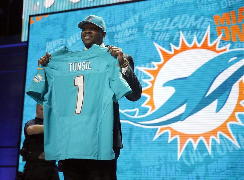 Mississippi's Laremy Tunsil poses for photos after being selected by the Miami Dolphins as the 13th pick in the first round of the 2016 NFL football draft, Thursday, April 28, 2016, in Chicago. (AP Photo/Charles Rex Arbogast)