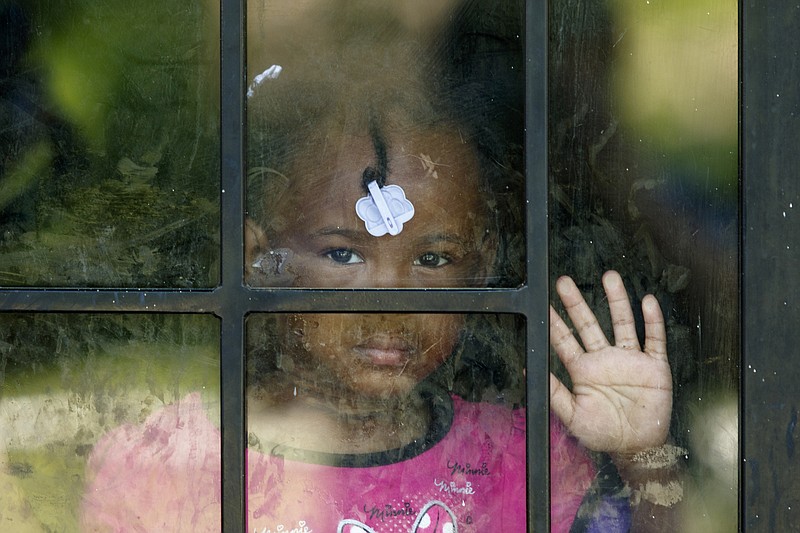 Tiara Wynn, niece of Marie McCallie, stares from the window of her home near the site of a recent shooting on Wednesday, April 20, 2016, after a wave of gang violence in Chattanooga, Tenn.