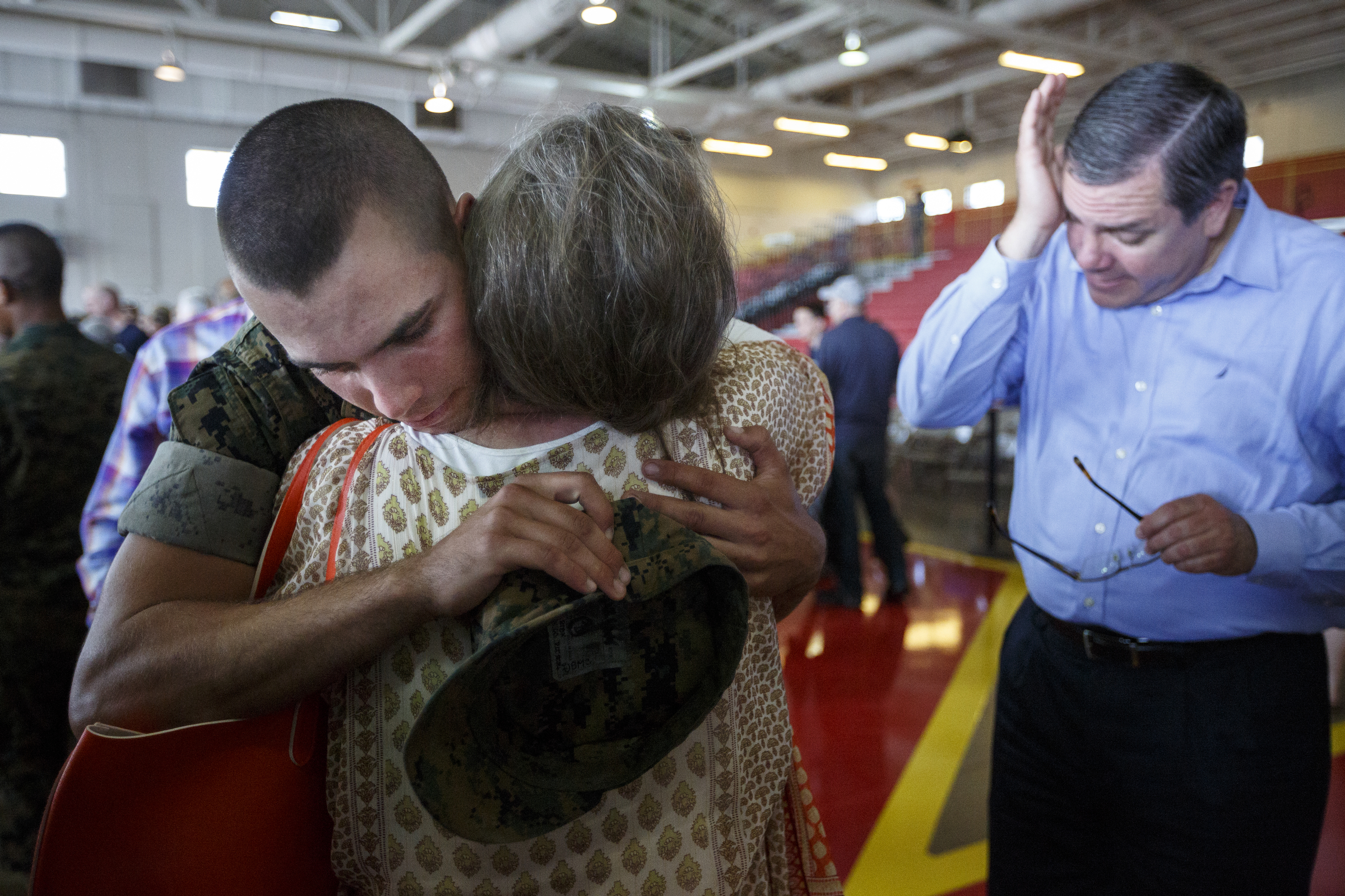 Dani Arthur hugs her son, Pfc. Winston Arthur, a new Marine, as his father Kevin wipes away tears upon seeing him for the first time since his departure for boot camp 13 weeks ago at the Marine Corps Recruit Depot on Thursday, April 28, 2016, in Parris Island, South Carolina. The new Marines were released to spend time with their families for family day on the day before their graduation ceremony.