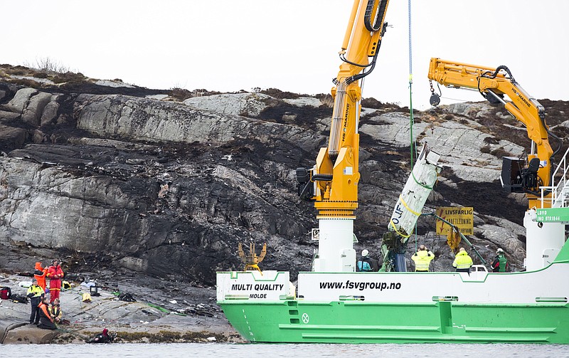 
              A recovery vessel lifts up parts of a crashed helicopter from off the island of Turoey, near Bergen, Norway, as emergency workers on the shoreline attend the scene Friday, April 29, 2016. The helicopter carrying around 13 people from an offshore oil field crashed Friday near the western Norwegian city of Bergen, police said. All aboard the helicopter were killed.  (Torstein Boe/NTB scanpix via AP) NORWAY OUT
            