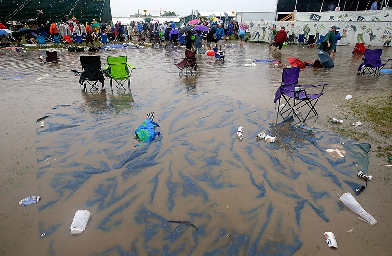 
              The Acura Stage area is flooded after a storm dumped several inches of rain on the second Saturday of the New Orleans Jazz Fest at the Fair Grounds, Saturday, April 30, 2016. (David Grunfeld/NOLA.com The Times-Picayune via AP)
            