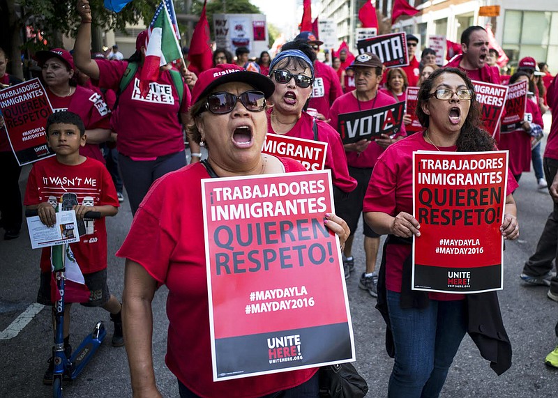 
              Hundreds of May Day marchers chanting slogans and carrying signs - these say 'Immigrant Workers Want Respect"- and at least one Donald Trump piÃ±ata, take to the streets of Los Angeles, calling for immigrant and worker rights and decrying what they see as hateful presidential campaign rhetoric, Sunday, May 1, 2016. It's one of several events in cities nationwide to call for better wages for workers, an end to deportations and support for an Obama administration plan to give work permits to immigrants in the country illegally whose children are American citizens.(David Crane/Los Angeles Daily News via AP) LA TIMES OUT VENTURA COUNTY STAR OUT
            