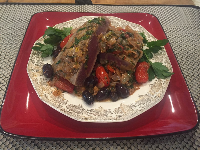 Yellowfin tuna with a sauce made from white wine, olives, cherry tomatoes and a lemon-induced olive oil is a delicious and easy-to-make dinner.