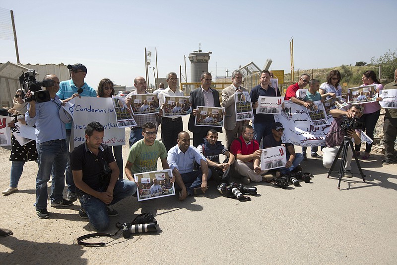 
              Palestinian journalists hold banners during a protest calling for the release of Palestinian journalist Omar Nazzal, who was arrested by Israeli authorities over the weekend, outside Ofer military prison near the West Bank city of Ramallah, Tuesday, April 26, 2016. (AP Photo/Majdi Mohammed)
            