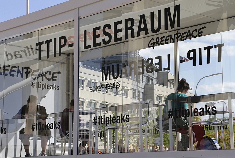 
              People read documents on the Trans-Atlantic talks to create a massive free trade zone between the United States and the European Union in a 'TTIP reading room' set up by Greenpeace in front of the Brandenburg Gate in Berlin, Germany, Monday, May 2, 2016. Greenpeace released confidential negotiating texts that the environmental group claims shows U.S. ill intent. (AP Photo/Ferdinand Ostrop)
            
