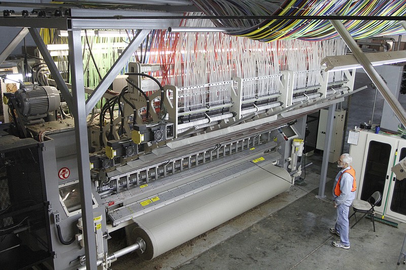 Doyle Weaver, machine operator, keeps and eye on the needles inside the Colortron machine. Workers at the Dixie Group carpet plant in Eton, Georgia, produced, inspected and shipped carpet.