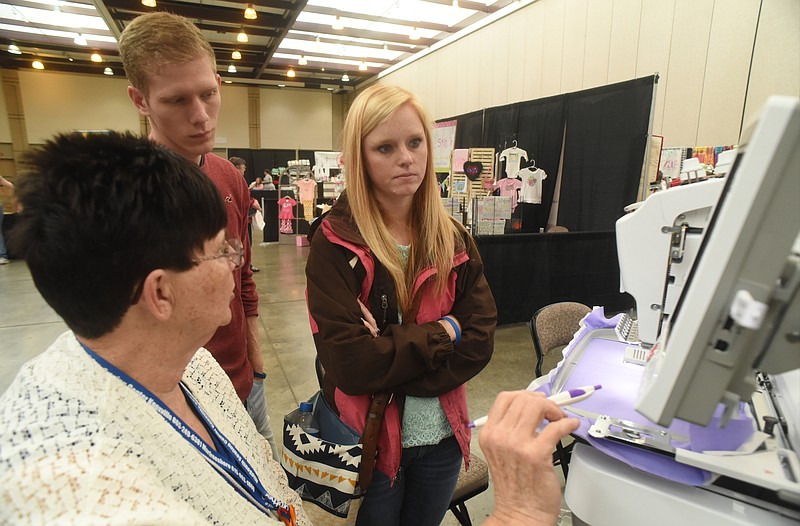 Carolyn French, left, with MidSouth Sewing, talks with Anna Miller, right, and Shaun Roberts Friday, April 22, 2016 at the Everything Embroidery Market at the Chattanooga Convention Center.