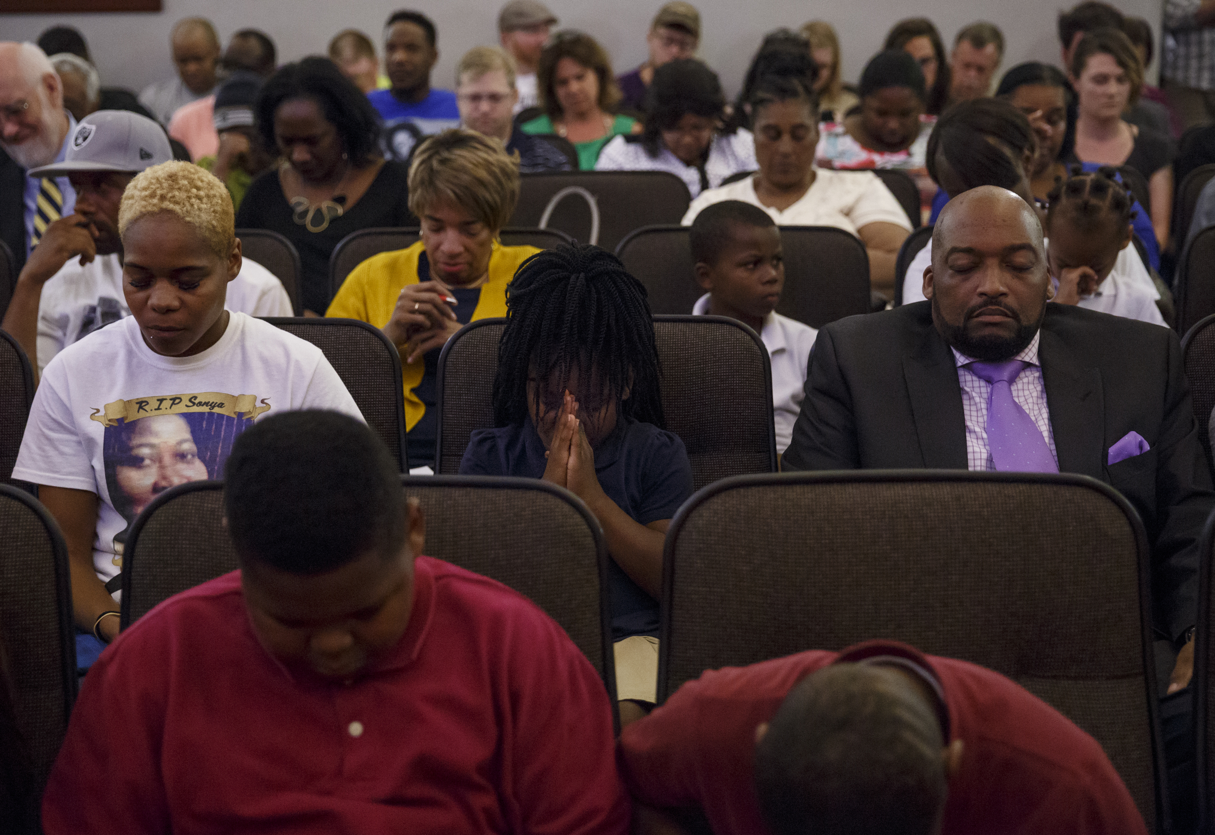 Community members bow their heads in prayer during a Chattanooga City Council Meeting on Tuesday, May 3, 2016, in Chattanooga, Tenn. Kevin Muhammad, with the Nation of Islam, delivered what he called a