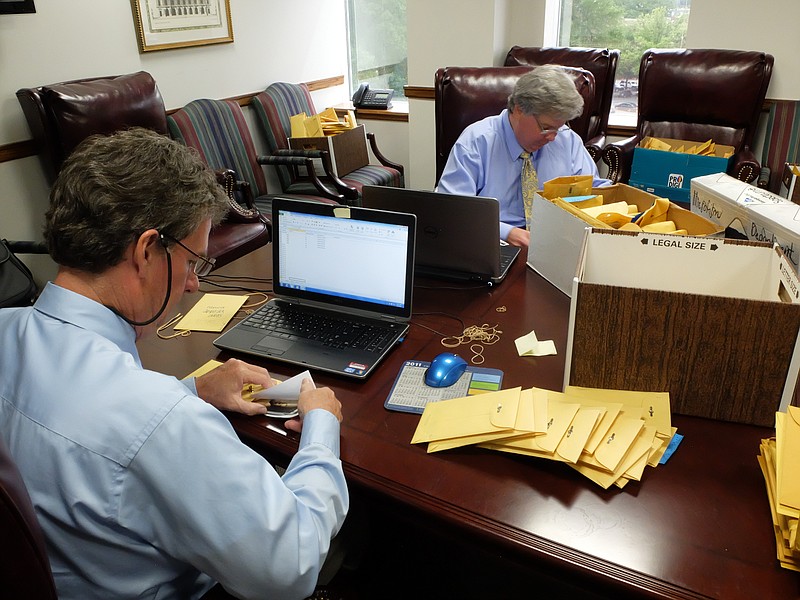 Hamilton County auditors Roger Kincer, left, and Harry Mansfield go through thousands of evidence files recently removed from the Medical Examiners office.