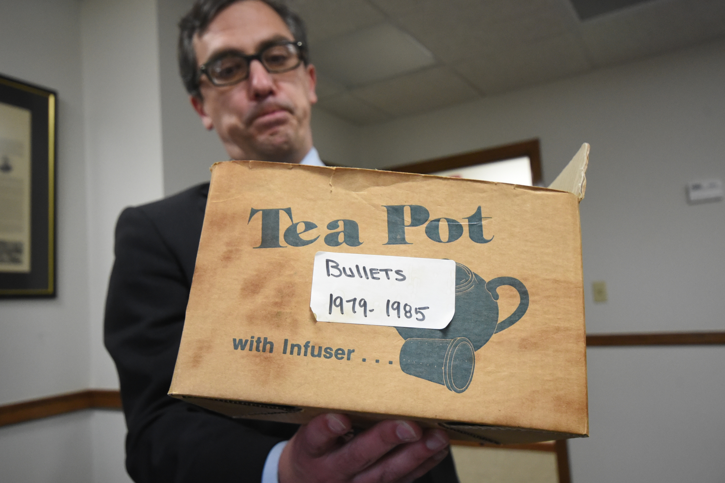 Attorney General Neal Pinkston holds a box full of bullets from shootings as he and Hamilton County auditors go through thousands of evidence files on Tuesday from the Medical Examiners office.