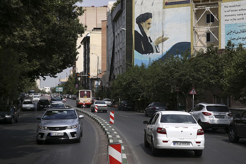 
              In this picture taken on Tuesday, July 7, 2015, cars drive past a painting of late Iranian revolutionary founder Ayatollah Khomeini at Bahonar street in northern Tehran, Iran. Chevrolet, the U.S. car brand once advertised as the “Heartbeat of America,” won’t be rolling new models through the streets of Iran anytime soon despite the recent lifting of sanctions under a nuclear deal with world powers. (AP Photo/Vahid Salemi)
            
