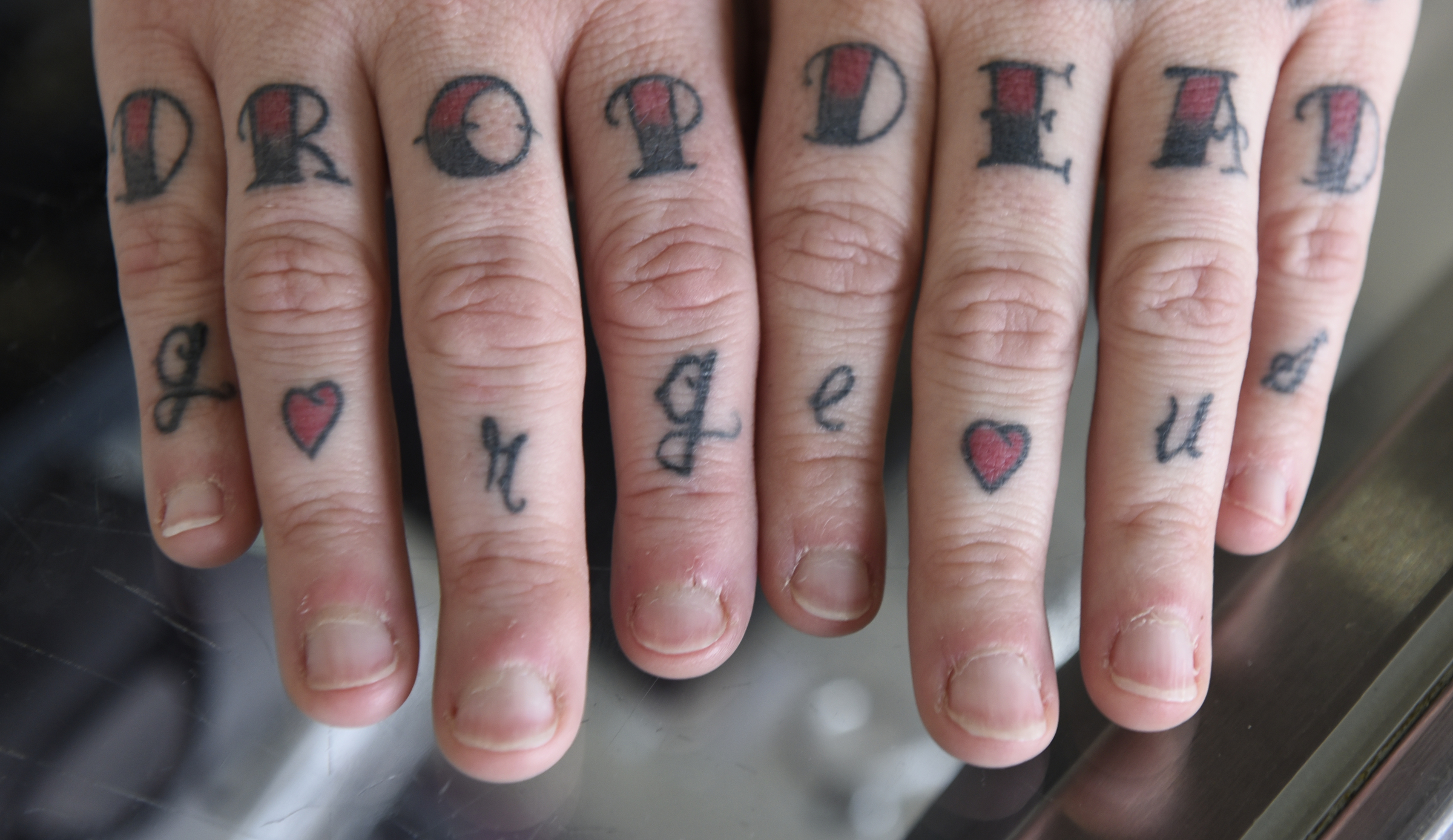 Tattoo and piercing artist Amanda Silvers shows her fingers with "drop dead gorgeous" tattooed across them at Freedom Tattoo on Tuesday, Apr. 26, 2016, in Chattanooga, Tenn.